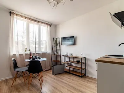 a living room with a table and chairs and a window at Boyana Loft - Central Sofia Studio in Sofia