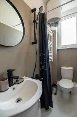 a bathroom with a sink and a mirror and a toilet at Largo Loft - Central Sofia Studio in Sofia