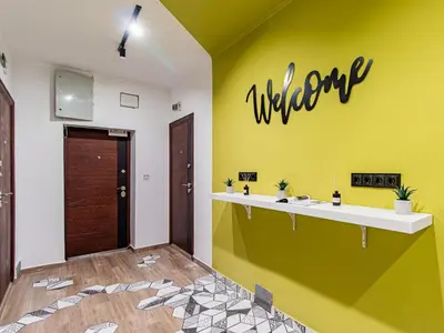 a bathroom with a yellow wall with the welcome sign on it at Largo Loft - Central Sofia Studio in Sofia
