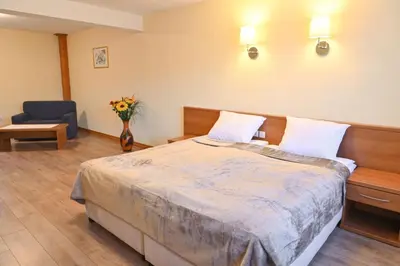 a bedroom with a bed and a vase of flowers at Къща за гости ГРАНИТ in Bansko