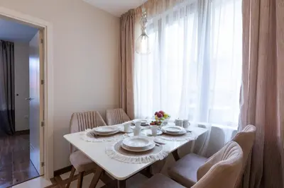 a white dining room table with chairs and a white tablecloth at Didi's Central Designer Apartments in Sofia