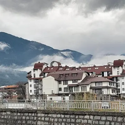 a group of buildings with mountains in the background at lux Apartament L201 in Bansko