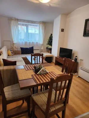 a living room with a table and chairs and a couch at Mountain paradise apartment in Bansko