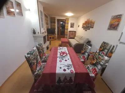 a living room with a table and a couch at Апартамент 9 in Pamporovo