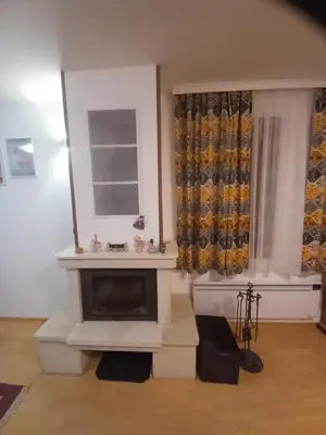 a living room with a fireplace and a window at Апартамент 9 in Pamporovo