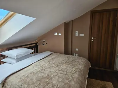 a bedroom with a large bed in a attic at Ioannis Apartment Bansko in Bansko
