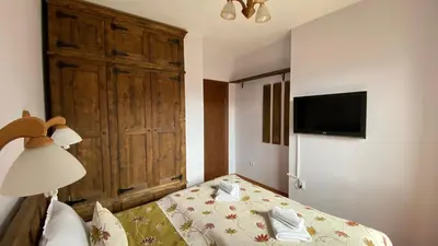 a bedroom with a bed with a large wooden door at Belvedere Holiday Club SPA&POOL Private Apartments in Bansko