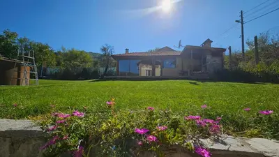 a house with pink flowers in a yard at Вила Доброво in Dobrovo