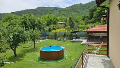 a backyard with a hot tub in the grass at Вила Доброво in Dobrovo