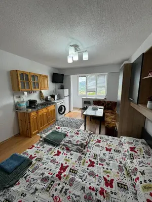 a bedroom with a bed with a flowered bedspread at Apartment sunny morning in Sandanski