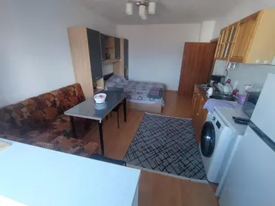 a kitchen with a couch and a table and a washing machine at Apartment sunny morning in Sandanski