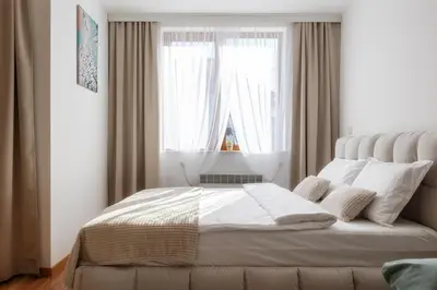 a bedroom with a bed with a large window at Pirin Sense Apartment Complex in Bansko
