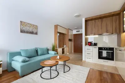 a living room with a blue couch and a table at Pirin Sense Apartment Complex in Bansko
