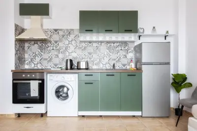 a kitchen with green cabinets and a washer and dryer at Pirin Sense Apartment Complex in Bansko