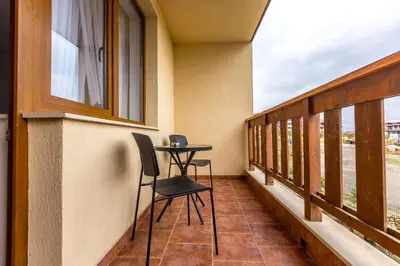 a balcony with a table and chairs on it at Pirin Sense Apartment Complex in Bansko