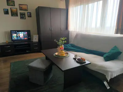 a living room with a couch and a table and a tv at Happy Stay 100mfrom Gondola with free Bottle of Wine and free Parking in Bansko