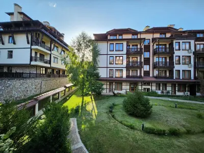 a group of buildings in a park with a tree at Luxury Downtown Appartment - 150m ski lift Gondola in Bansko