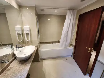 a bathroom with a sink and a bath tub and a toilet at Luxury Downtown Appartment - 150m ski lift Gondola in Bansko