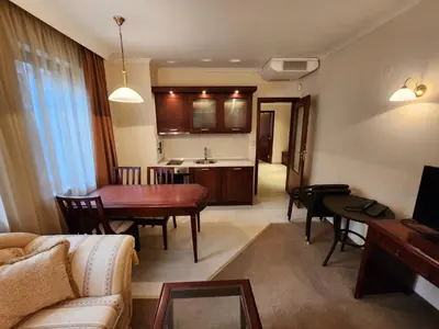 a living room with a couch and a table and a kitchen at Luxury Downtown Appartment - 150m ski lift Gondola in Bansko