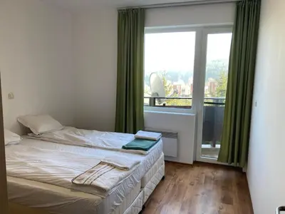 a bedroom with a bed and a large window at Apartment 26А Detelina Residence in Bansko