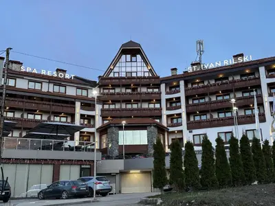 a large building with cars parked in front of it at Family Luxury Private Apartments in 4 star SPA Resort St Ivan Rilski, Bansko in Bansko