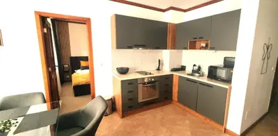 a kitchen with a counter and chairs in a room at Family Luxury Private Apartments in 4 star SPA Resort St Ivan Rilski, Bansko in Bansko