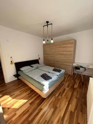 a bedroom with a bed and a wooden floor at Family friendly downtown apart in Sofia