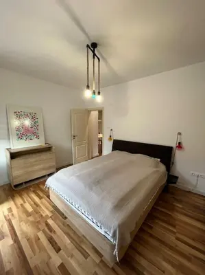 a bedroom with a large bed and wooden floors at Family friendly downtown apart in Sofia