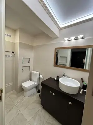 a bathroom with a sink and a toilet and a mirror at Family friendly downtown apart in Sofia