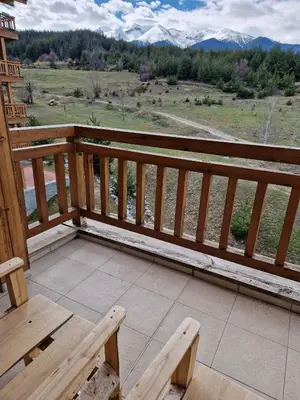 a wooden deck with a bench and a view of mountains at Saint John Hill Apartment in Bansko