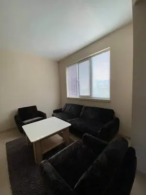a living room with two couches and a table at ЛАЗАРОВИ in Hisarya