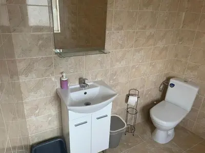 a bathroom with a sink and a toilet and a mirror at ЛАЗАРОВИ in Hisarya