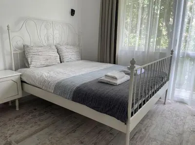 a white bed in a bedroom with a window at 3 BR Apt, Spacious, Near South Park in Sofia
