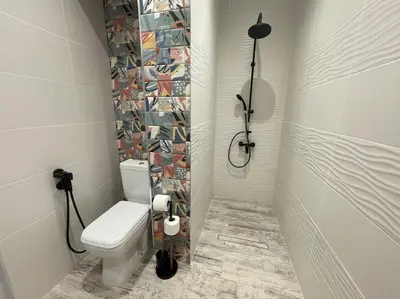 a bathroom with a toilet and a mosaic tile wall at 3 BR Apt, Spacious, Near South Park in Sofia