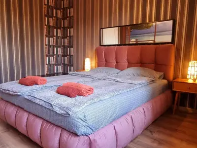 a bedroom with a large bed with two pillows on it at Central Apartment in Sofia