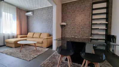 a living room with a couch and a table and chairs at Central Apartment in Sofia