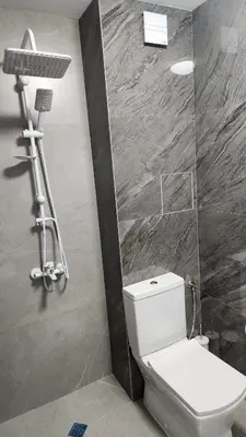 a bathroom with a white toilet and a shower at Димоти Апартхотел in Sofia