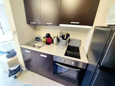 a small kitchen with a sink and a refrigerator at Spacious luxury studio with mountain view - SPA available in Bansko