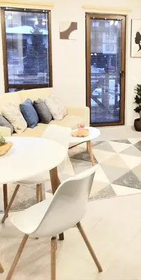 a living room with a white couch and tables at Spacious luxury studio with mountain view - SPA available in Bansko