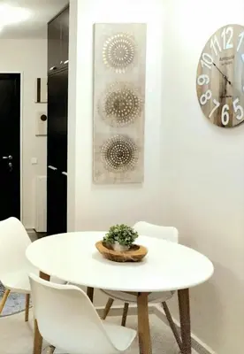 a white dining room table with white chairs and a clock at Spacious luxury studio with mountain view - SPA available in Bansko