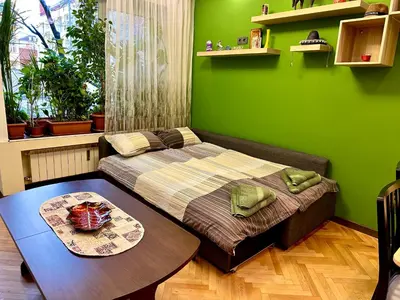 a green room with a bed and a table at Luxury Oasis in absolute Center of Sofia in Sofia