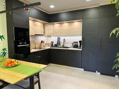 a kitchen with black cabinets and a table with a bowl of oranges at Luxury Oasis in absolute Center of Sofia in Sofia