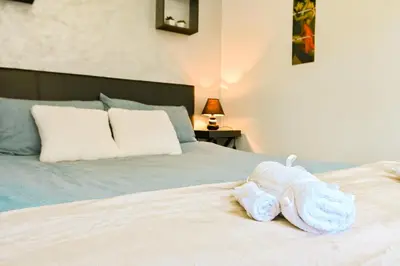 a bed with a stuffed animal on top of it at Neofit Rilski Apartment (near Vitoshka street) in Sofia