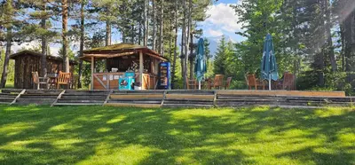 a gazebo with chairs and umbrellas in the grass at Green Peaks Suite in Pirin Golf & County Club in Razlog