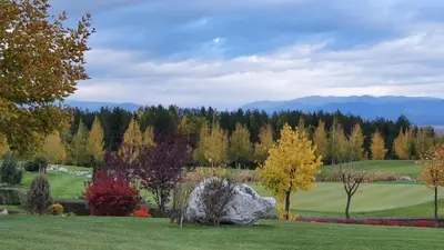 a garden with a rock in the middle of a field at Green Peaks Suite in Pirin Golf & County Club in Razlog