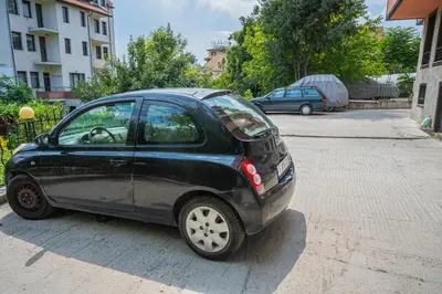 a small black car parked in a parking lot at Апартаменти Мечето in Sandanski