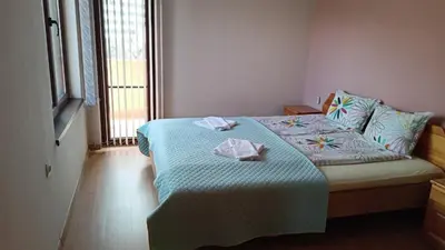 a bedroom with a bed with two towels on it at Апартаменти Мечето in Sandanski