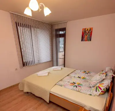 a bedroom with a bed and a window at Апартаменти Мечето in Sandanski