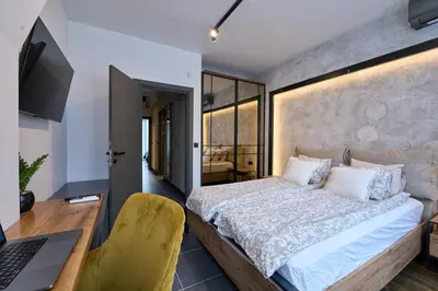 a bedroom with a bed and a desk with a laptop at Luxury 2 Bedroom Apartment - Private Garden in Sofia