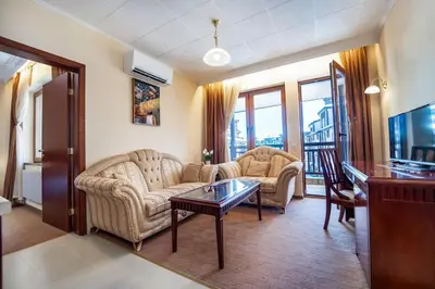 a living room with two couches and a table at Ski Lift Delight Bansko Apartment in Bansko